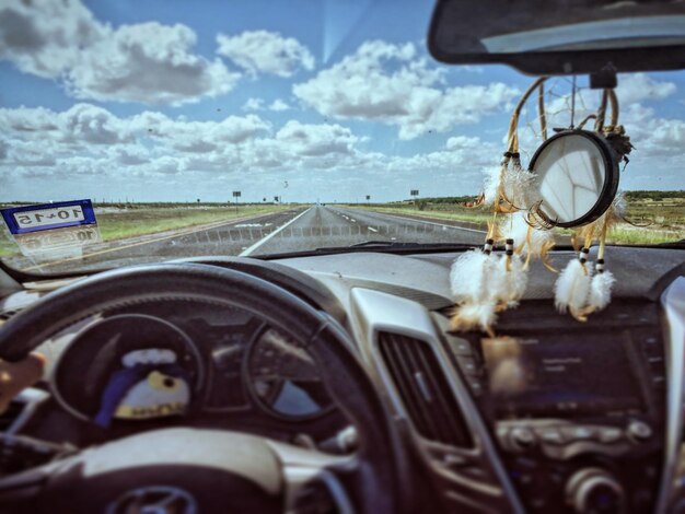 Photo route contre le ciel vue à travers le pare-brise de la voiture