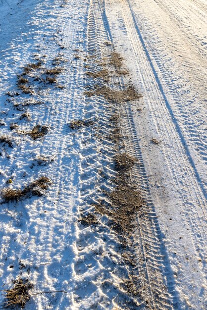 Route dangereuse en hiver route boueuse glissante avec des traces de voitures en hiver après les chutes de neige