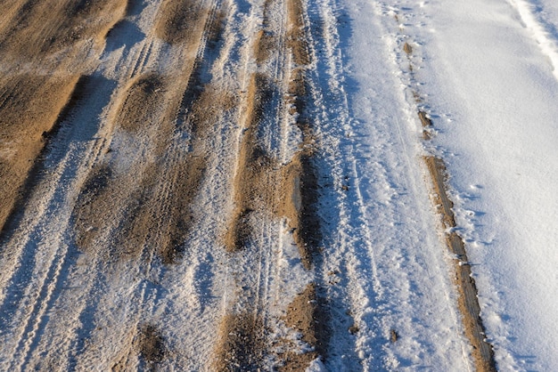 Route dangereuse en hiver route boueuse glissante avec des traces de voitures en hiver après les chutes de neige