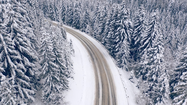 Route dans la forêt de montagne d'hiver. Vue drone.