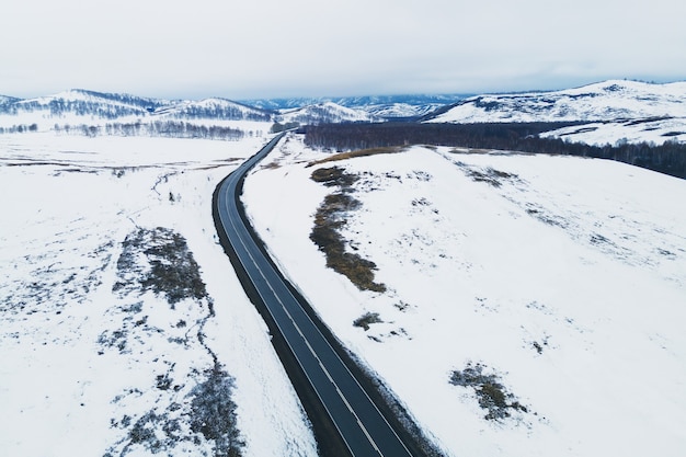 Route dans les montagnes enneigées au début du printemps. Vue aérienne de drone. Beau paysage d'hiver. Oural du Sud, Russie