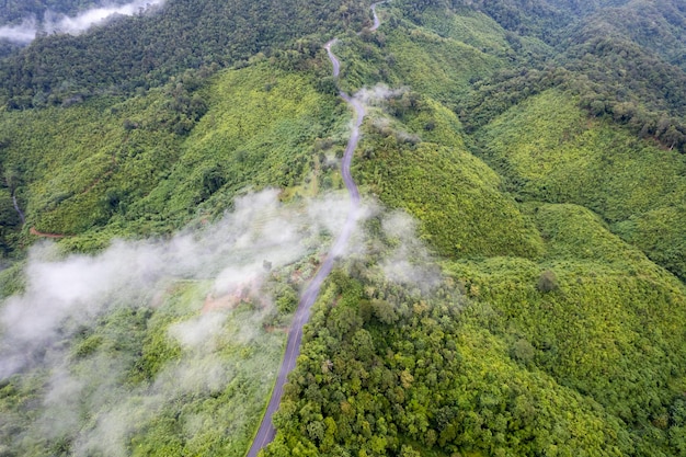 Une route dans les montagnes avec des nuages dans le ciel