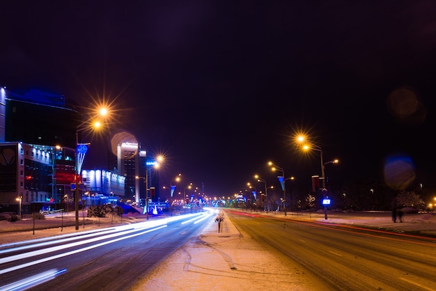 Route dans la nuit d'hiver, ville, voitures, lumières, vitesse.