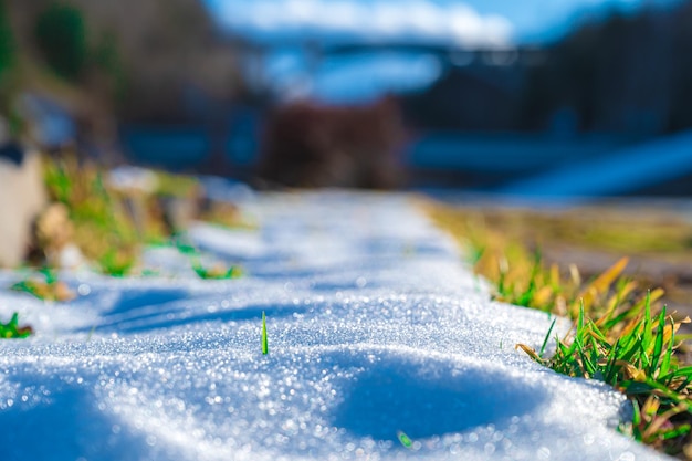 Route enneigée où l'on peut voir un peu d'herbe