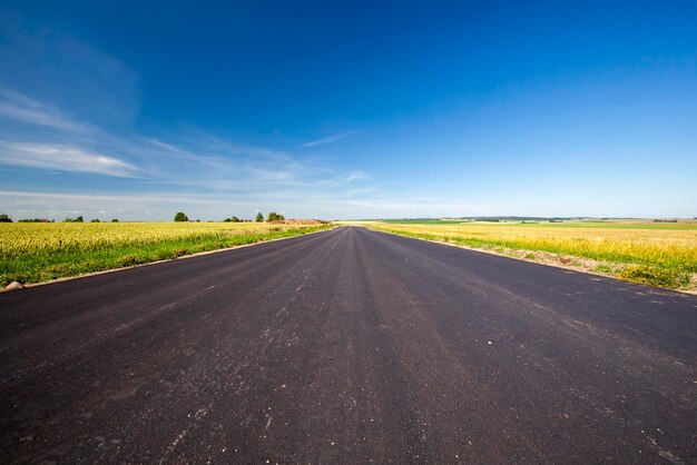 Une route goudronnée avec un ciel bleu sans nuages