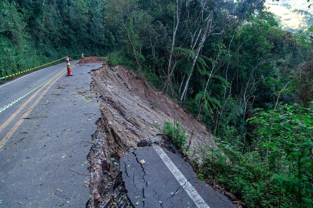 Route goudronnée endommagée par un glissement de terrain dans une zone montagneuse