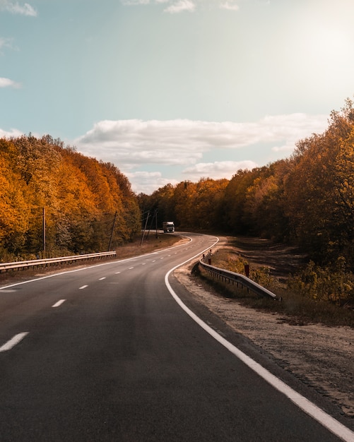 route incurvée avec des arbres chauds d'automne sur les côtés