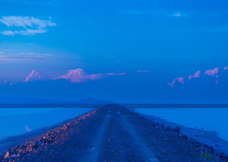 Photo route menant à l'horizon au coucher du soleil dans le désert