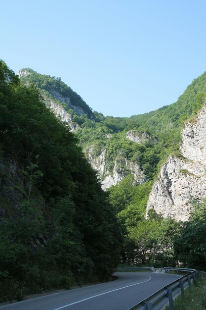 Photo une route menant vers les montagnes contre un ciel dégagé