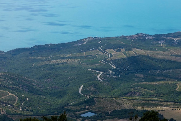 Route de montagne sinueuse traversant la forêt sur fond de mer Vue d'en haut Paysage