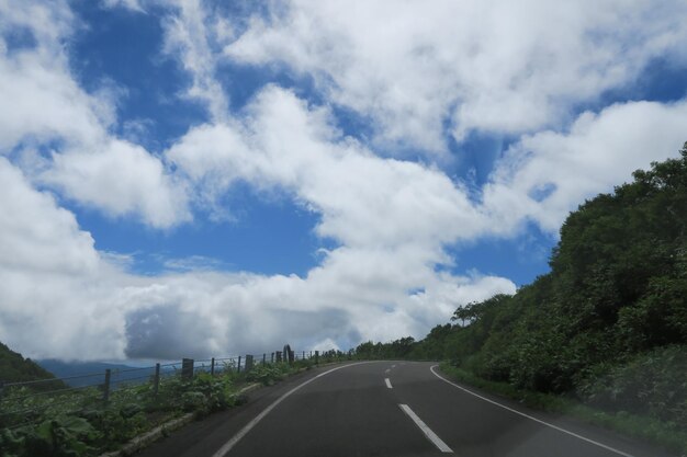 Photo une route par les arbres contre le ciel