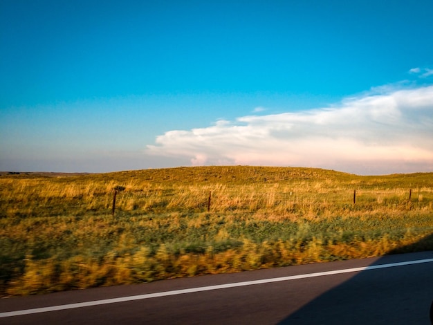 Photo la route par le champ contre le ciel bleu