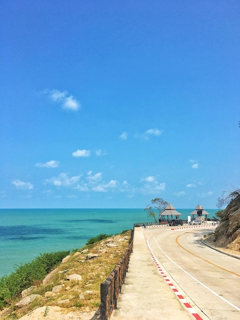 La route par la mer contre le ciel bleu