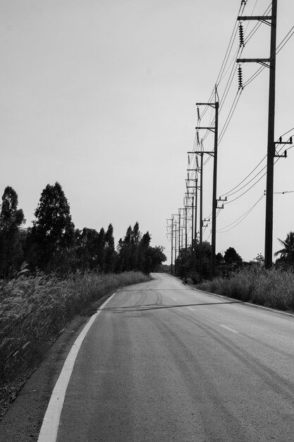 Route par pylône électrique contre le ciel