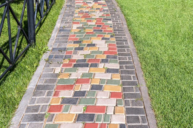 Une route pavée colorée à travers une pelouse luxuriante par une journée ensoleillée