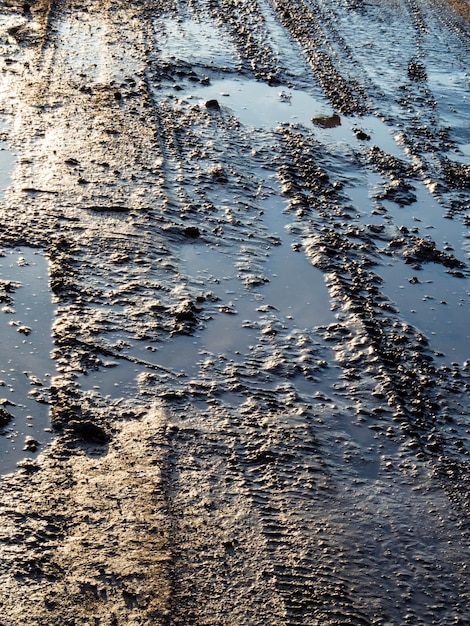 Route rurale sale avec traces de pneus profondes