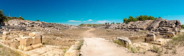 une route de terre avec un ciel bleu et un bâtiment en arrière-plan