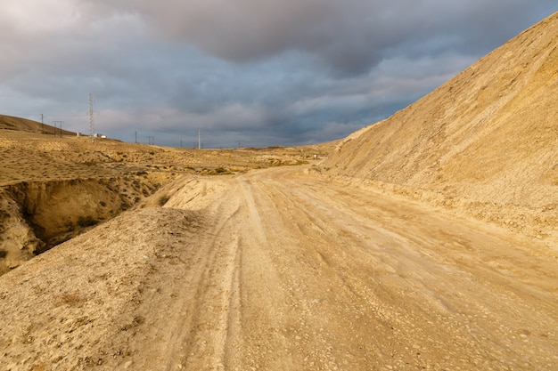 Photo route vers les volcans de boue de gobustan près de bakou, azerbaïdjan. route et ciel orageux