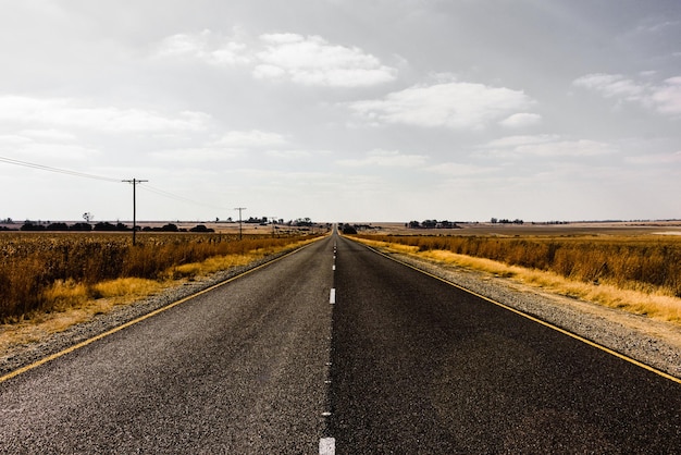 Une route vide au milieu d'un champ contre le ciel