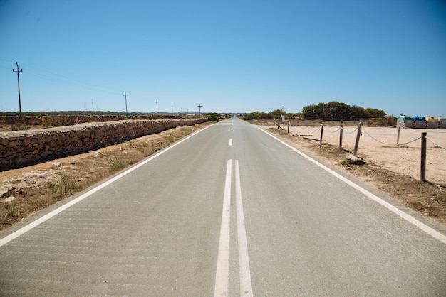 Une route vide contre un ciel bleu clair