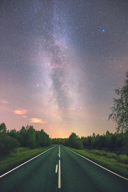 Une route vide contre la voie lactée la nuit.