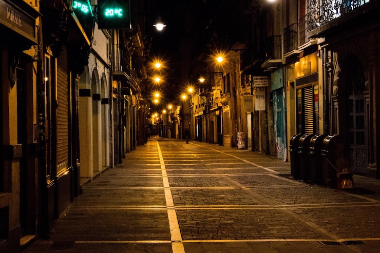 Photo une route vide le long de bâtiments éclairés la nuit