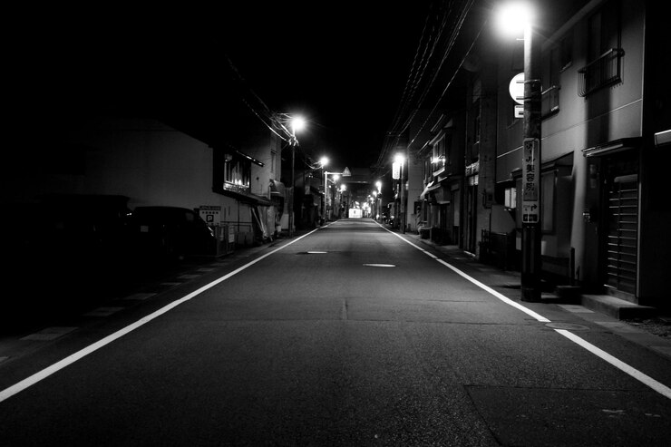 Photo une route vide le long de bâtiments éclairés la nuit