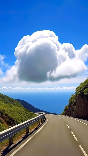 une route avec une voiture qui y roule et un nuage dans le ciel