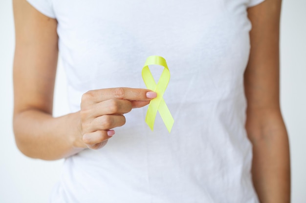 Ruban jaune dans le symbole des mains Cancer de la vessie