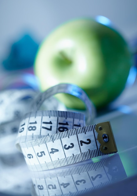 Ruban à mesurer blanc et pomme sur fond. concept de régime