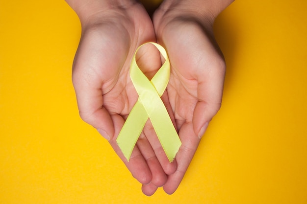 Ruban d'or pour les enfants comme symbole de la sensibilisation au cancer infantile. ruban jaune sur place