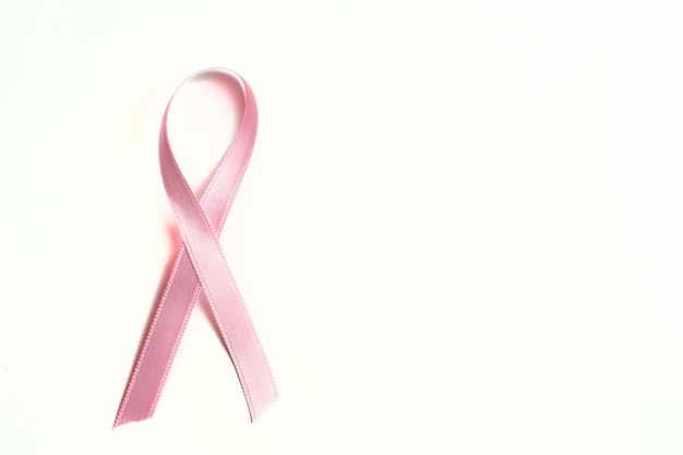 Ruban rose sur fond blanc symbole de la sensibilisation au cancer du sein et du cancer chez les enfants