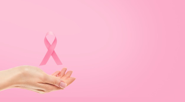 Un ruban rose de sensibilisation au cancer du sein Une main féminine tenant un ruban rose volant symbole de la lutte contre le cancer du sein La sensibilisation au Cancer du sein et le Jour mondial du cancer du mois d'octobre