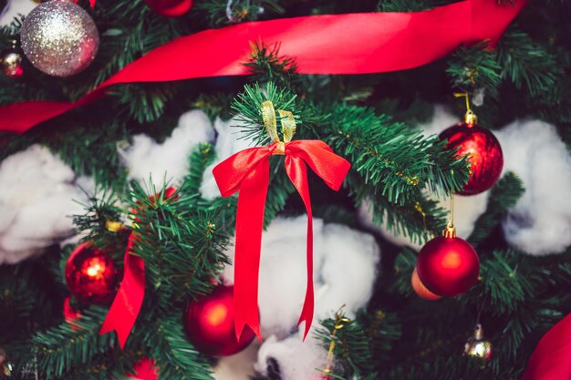 Ruban rouge avec des boules de Noël rouges et des boules d'argent ornent le fond de Noël du sapin de Noël