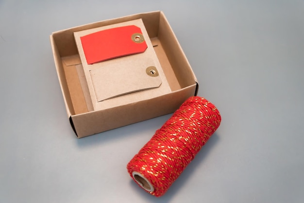 Ruban rouge et étiquettes de nom pour emballer les cadeaux du Nouvel An ruban rouge en coton avec des inserts dorés place pour le texte atmosphère de noël cadeaux du nouvel an vacances en famille