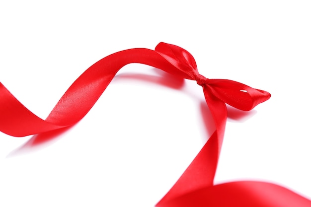 Ruban de satin rouge brillant et arc isolé sur blanc