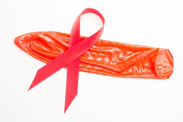 Photo ruban de sensibilisation rouge couché sur le préservatif