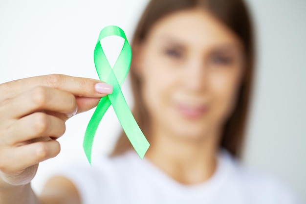 Ruban vert à la main comme symbole de sensibilisation au cancer du lymphome