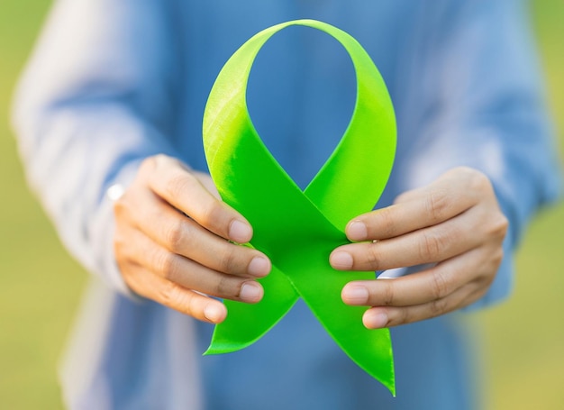 Photo un ruban vert mis dans les mains de l'homme journée mondiale de la santé mentale