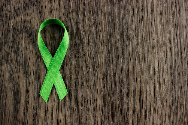 Ruban vert. santé mentale, symbole de sensibilisation sur le fond en bois