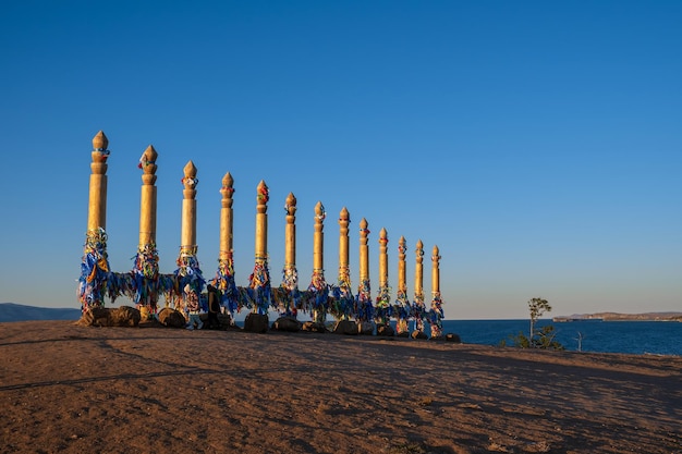 Rubans colorés sur les piliers en bois de la place bouriate sacrée sur le cap Burkhan dans le village de Khuzhir sur l'île d'Olkhon, lac Baïkal, Russie