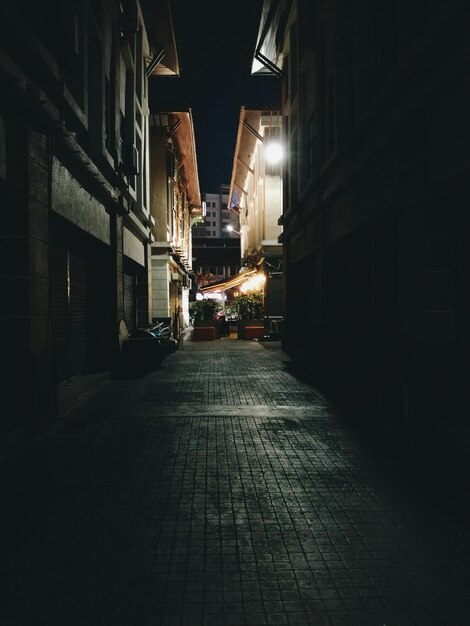 Photo rue au milieu des bâtiments la nuit