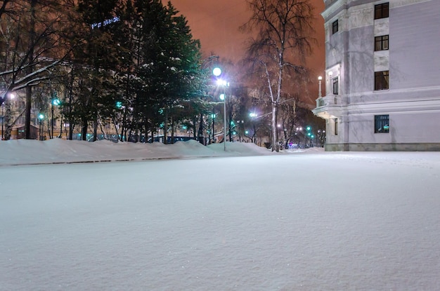 Une rue couverte de neige en face d'un bâtiment avec un panneau qui dit "patin à glace '