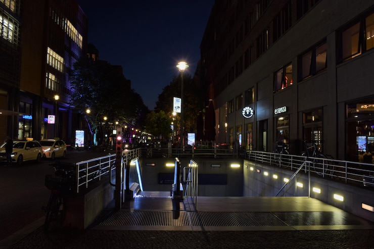 Photo une rue éclairée au milieu des bâtiments la nuit.
