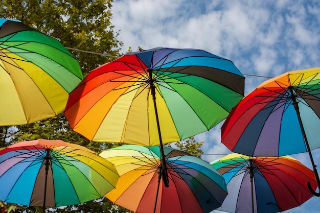 La rue est décorée de nombreux parapluies ouverts de couleur rouge