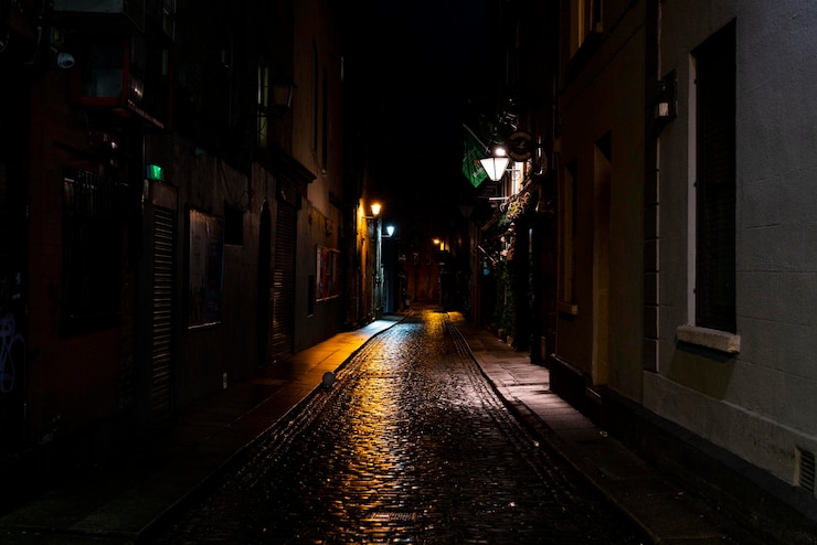 Photo une rue étroite au milieu des bâtiments la nuit.