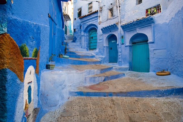 Rue étroite turquoise avec maisons bleues et escalier à Chefchaouen au Maroc