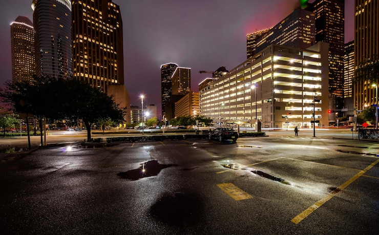 Photo rue humide contre les bâtiments éclairés pendant la nuit