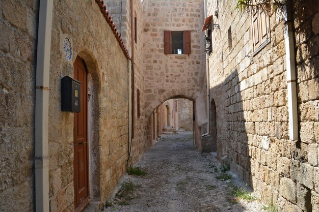 rue médiévale étroite avec des murs de briques et des portes et fenêtres cintrées