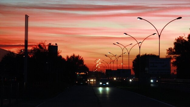 Photo rue par silhouette lumières de rue contre le ciel au coucher du soleil